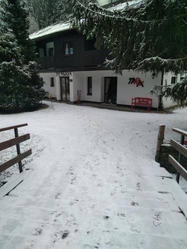 a snow covered yard in front of a building at pension TARA in Teplice nad Metují