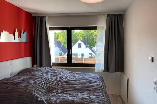ベンドルフにあるAppartment mit Blick auf Schloss Saynのベッドと大きな窓のある寝室