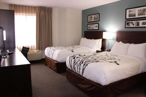 a hotel room with two beds and a television at Sleep Inn Chattanooga - Hamilton Place in Chattanooga