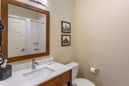a bathroom with a sink and a toilet and a mirror at Comfort Suites in Clarksville