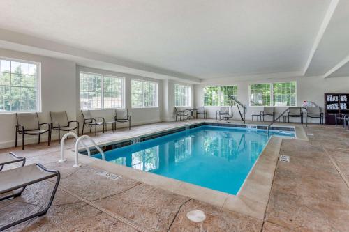 a pool in a room with chairs and a table at Comfort Suites Clarksville near Governors Square Mall in Clarksville