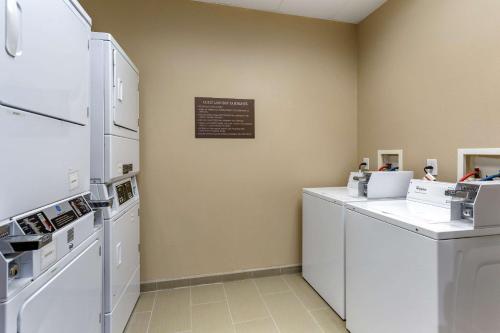 a laundry room with white appliances and a sign on the wall at Comfort Suites Clarksville near Governors Square Mall in Clarksville