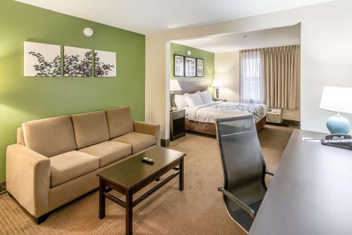 a hotel room with a couch and a bed at Sleep Inn & Suites Ruston Near University in Ruston