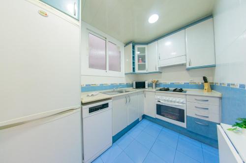 a kitchen with white cabinets and blue tile floors at Ahllenrock Cornella Cozy 15 Min Airport Barcelona in Cornellà de Llobregat