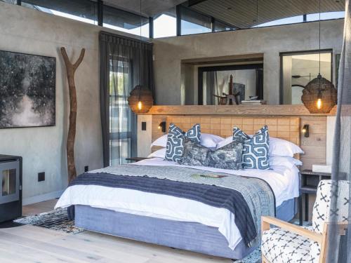 a bedroom with a large bed with blue and white pillows at Perivoli Lagoon House in Stanford