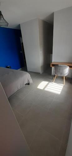 a bedroom with a bed and a table on a tiled floor at La Maison de Léobin in Véranne