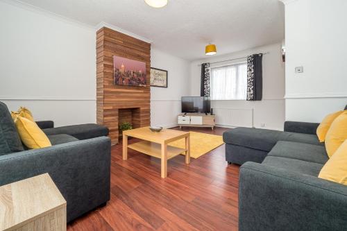 a living room with two blue couches and a table at Spacious House for Contractors with plenty of street parking by Great Northampton Stays in Kingsthorpe