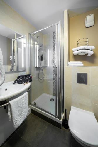 a bathroom with a shower and a toilet and a sink at ibis Styles Saint Brieuc Plerin in Plérin
