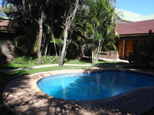 a swimming pool in the yard of a house at Lepha Guest House in Onverwacht
