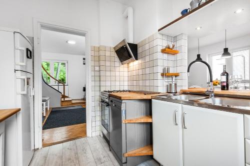 a kitchen with white cabinets and a sink at Carpe Diem in Gdynia