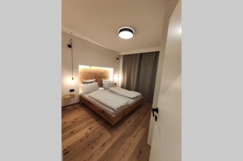 a bedroom with a large bed and wooden floors at Appartement Toni in Sand in Taufers