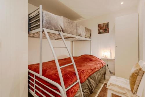 una camera con letto a castello e coperta rossa di Appartement Studio Wenduine a De Haan