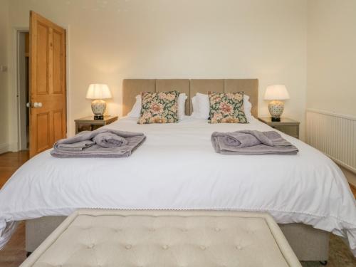 a bedroom with a large white bed with two lamps at High Torver House in Coniston