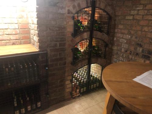 a room with a brick wall with three wine racks at Penzion U Hujňáků in Rohatec