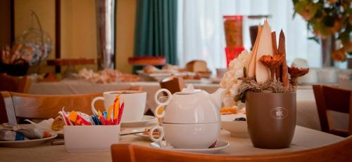 a table with cups and utensils on it at Aerhotel Phelipe in SantʼEufemia Lamezia