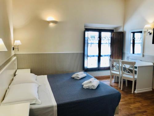 ein Schlafzimmer mit einem Bett mit zwei Handtüchern darauf in der Unterkunft Relais Campanile Adelaide in Florenz