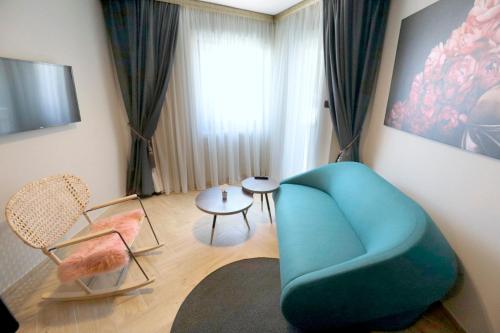 een woonkamer met een blauwe stoel en een tafel bij Villa Verica in Baška Voda