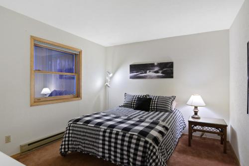 a small bedroom with a bed and a window at Snowfire 312A in Angel Fire