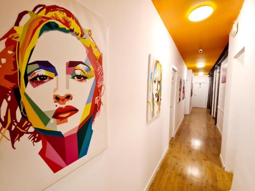 a hallway with a painting of a woman on a wall at Arc House Madrid - Puerta del Sol Only Adults in Madrid
