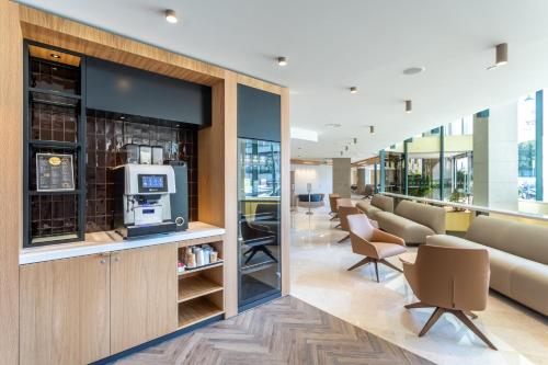 a waiting area in a hospital with chairs and a bar at Holiday Inn Lisbon by IHG in Lisbon