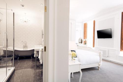 a white bathroom with a tub and a tv at Beamish Hall Country House Hotel, BW Premier Collection in Stanley
