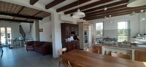 SANTA MARIA DI LORGANA في Minerbio: مطبخ وغرفة معيشة مع طاولة وكراسي