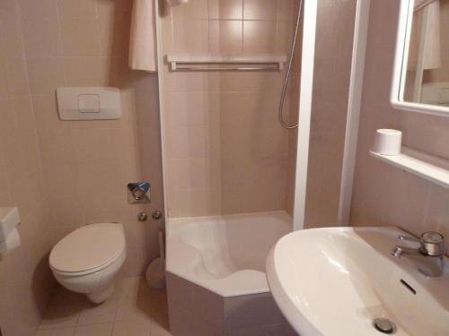 a bathroom with a toilet and a shower and a sink at SUITE25 GOLFHOTEL in Carezza al Lago