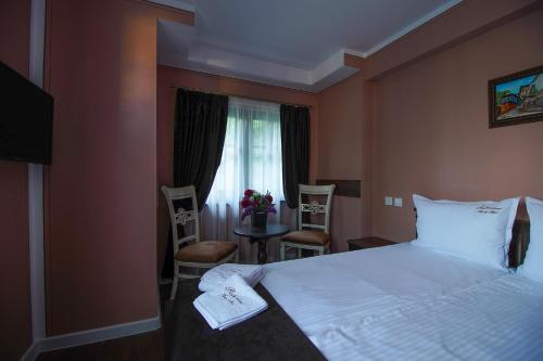 a bedroom with a bed and a table and chairs at Pulpudeva Family Hotel in Plovdiv