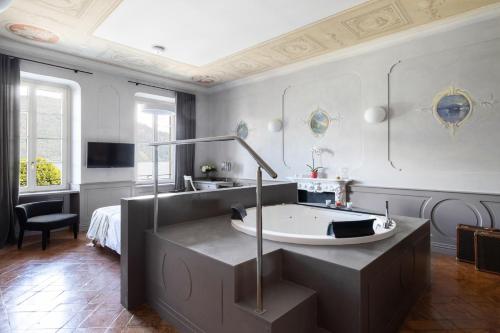 a bathroom with a tub and a tv in a room at Hotel Cannobio in Cannobio