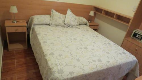 a bedroom with a bed with two nightstands and two lamps at Hotel Lido in Mar del Plata