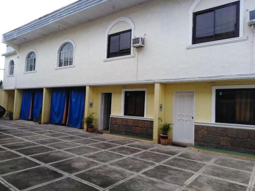 八打雁的住宿－RedDoorz near SM Batangas City，前面有蓝色窗帘的白色建筑