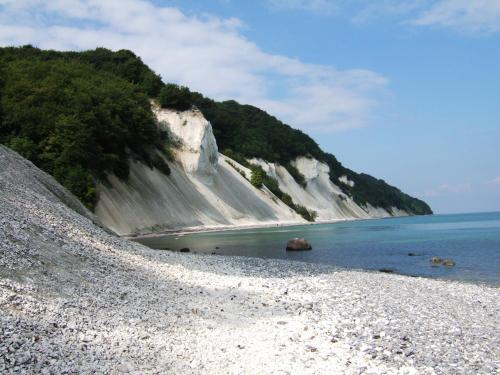 a rocky beach with water and a mountain at Tiendegaarden Møns Klint in Borre