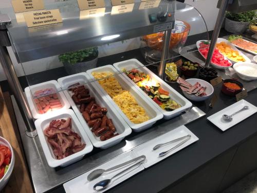 a buffet with many trays of food on a counter at Aparthotel Milenij in Baška Voda
