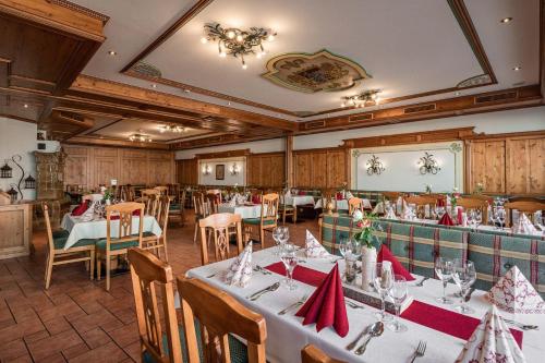 una sala da pranzo con tavoli e sedie con tovaglioli rossi di Hotel Bayrischer Löwe a Osterhofen
