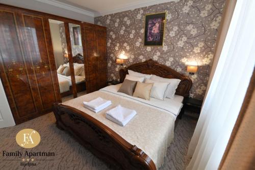 ein Schlafzimmer mit einem großen Bett mit zwei Kissen darauf in der Unterkunft Family apartman Bijeljina in Bijeljina