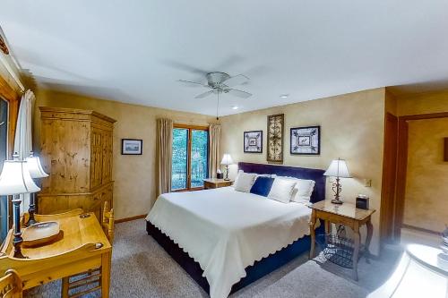 a bedroom with a large bed and a desk at Birchwood: Bay View in Harbor Springs