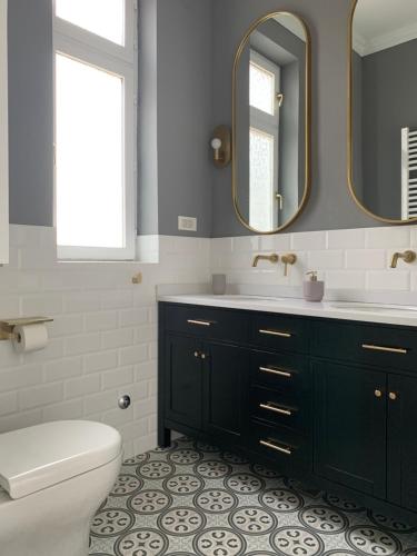 een badkamer met een toilet, een wastafel en spiegels bij Dragonfly Residence in Belgrado