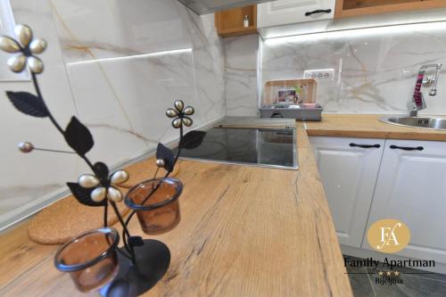 a kitchen with two plants on a wooden counter at Family apartman Bijeljina in Bijeljina