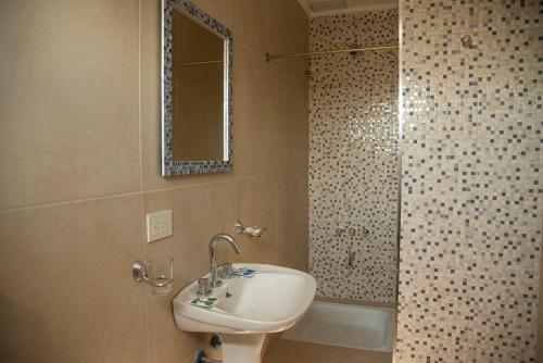 a bathroom with a sink and a shower at Morada Suites in Campana