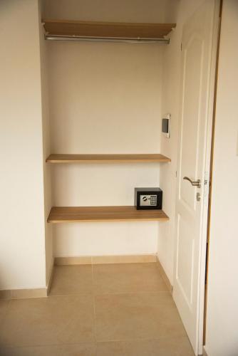 カンパーナにあるMorada Suitesのウォークインクローゼット(木製の棚、時計付)