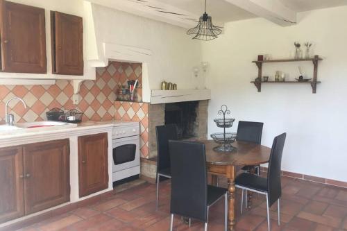 une cuisine avec une table et des chaises dans une cuisine dans l'établissement Cabanon de charme en plein coeur des vignes, à Pertuis