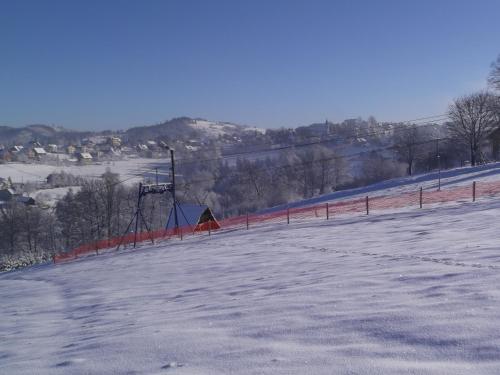 a person is skiing down a snow covered slope at Willa Szus in Koniaków