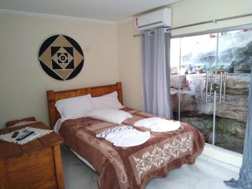 a bedroom with a bed and a window at Cafe Preto Pousada e Bistrô in Mucugê