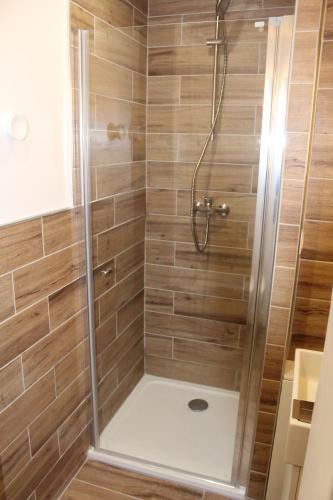 La salle de bains est pourvue d'une douche et de carrelage en bois. dans l'établissement Studio hyper centre avec vue sur les Pyrénées, à Saint-Jean-de-Luz