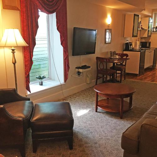 a living room with a couch and a table and a television at Morris House Hotel in Philadelphia