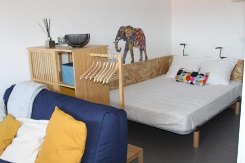 - un salon avec un canapé bleu et une statue de girafe dans l'établissement Studio hyper centre avec vue sur les Pyrénées, à Saint-Jean-de-Luz