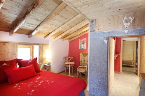 a bedroom with a red bed and a table at Les chalots de Gérardmer, Chambre d'Hôtes in Gérardmer