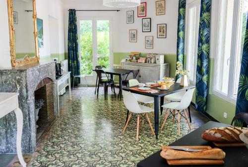 - un salon avec une table, des chaises et une cheminée dans l'établissement Domaine Castell de Blés, à Saint-Génis