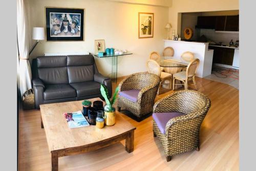 a living room with a couch and chairs and a table at Nellens apartment Knokke in Knokke-Heist