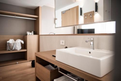 ein Badezimmer mit einem weißen Waschbecken und einem Spiegel in der Unterkunft Be Place in Trient
